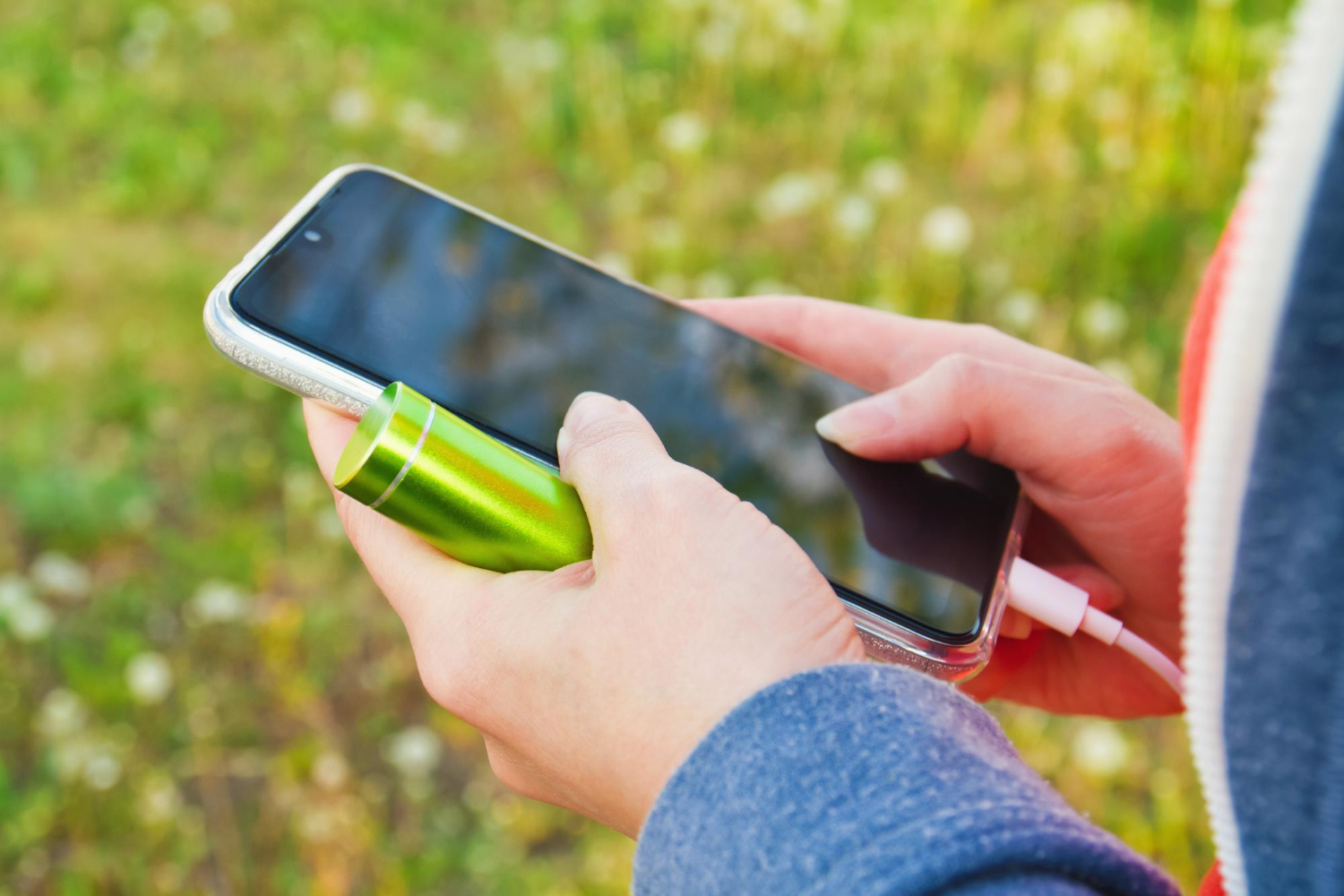kız telefon ve şarj için pil tutuyor